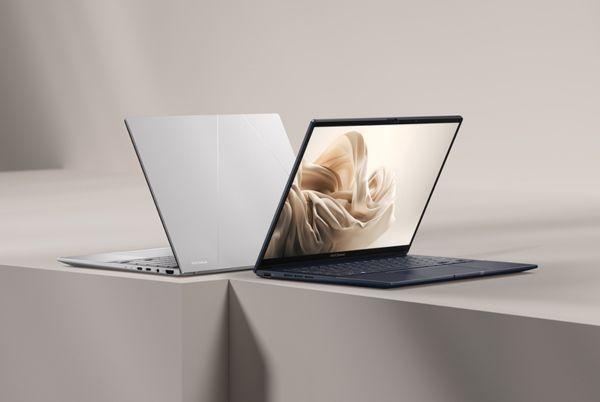 two Asus ZenBook 14 laptops are sitting on a table with one open