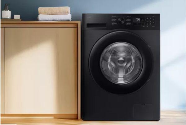 a Samsung Series 5 AI washing machine sitting next to a wooden cabinet
