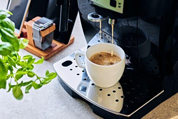 a cup of coffee is being poured into a cup on a table