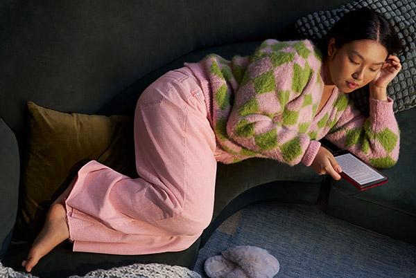 woman lying down reading a kindle