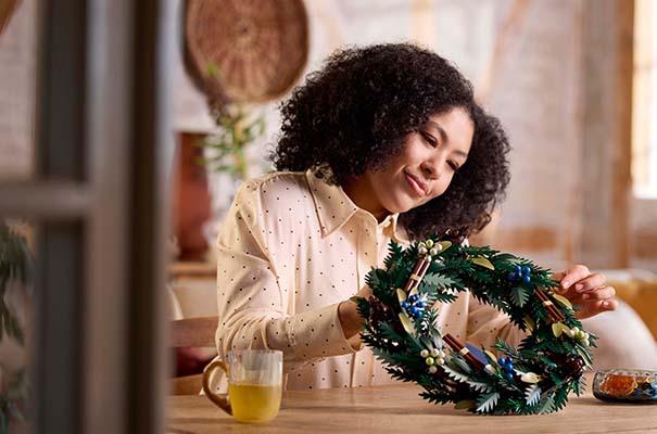 a woman is making a wreath on a table