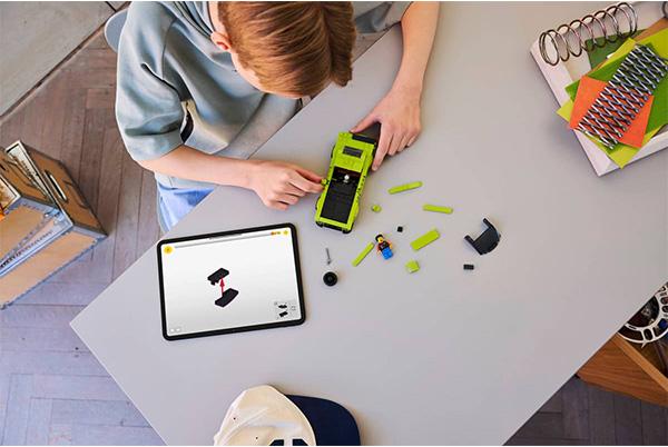 a young boy is working on a toy at a table