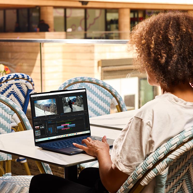 a woman sitting at a table with a laptop on it