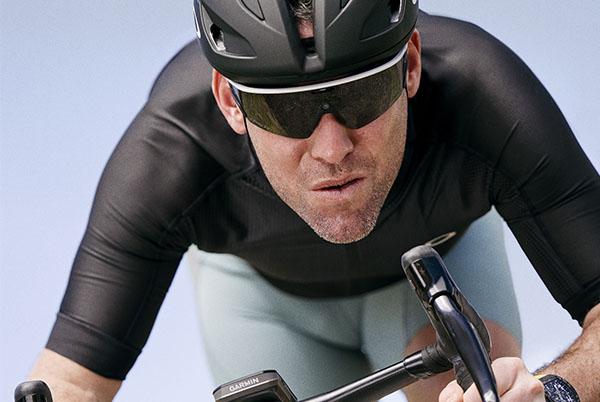 a man in a helmet and black shirt riding a bike