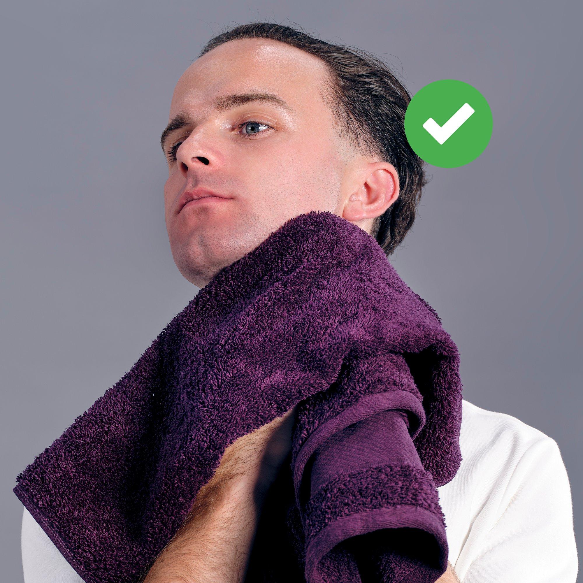 a man with a towel on his neck and a green check mark