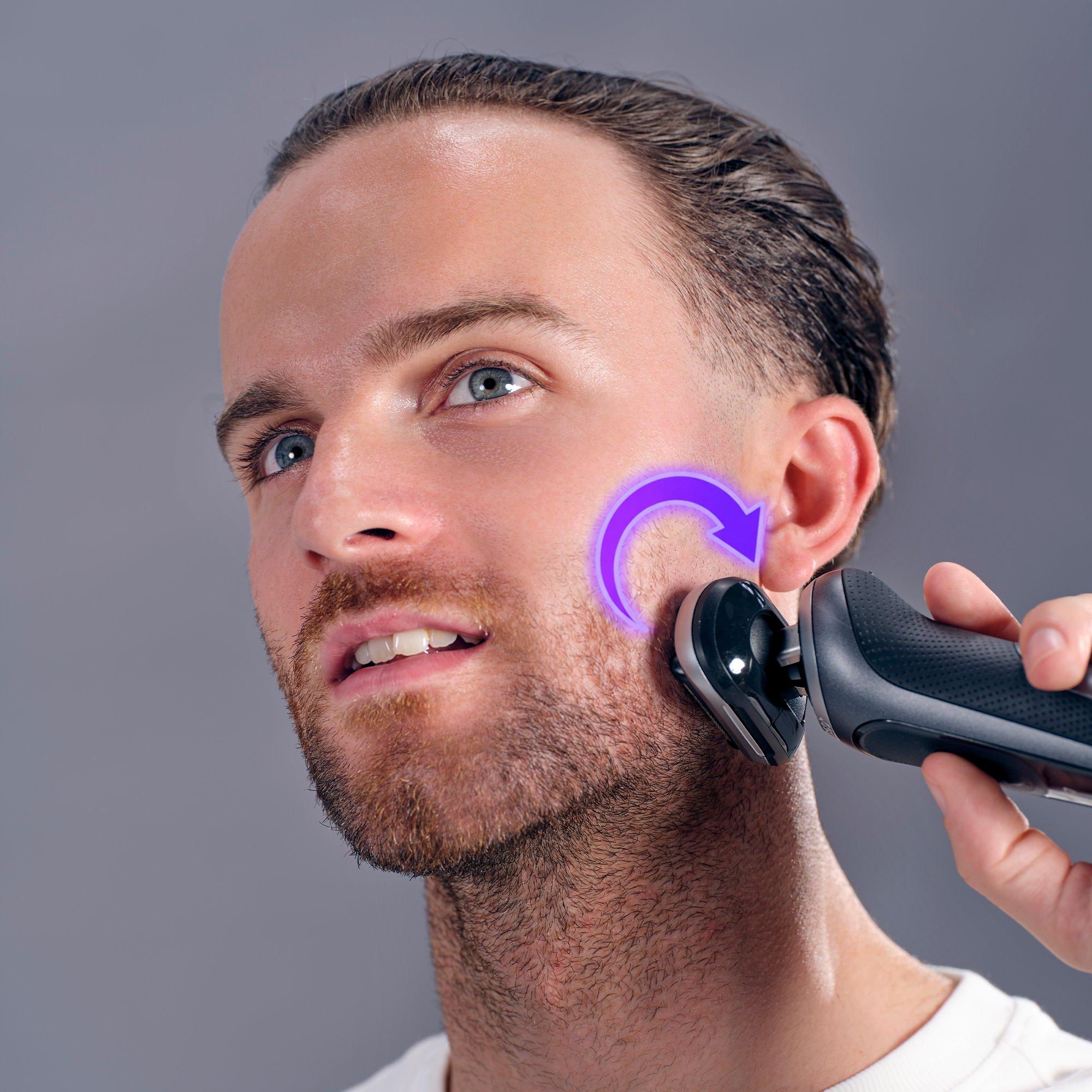 a man with a purple light on his face shaving