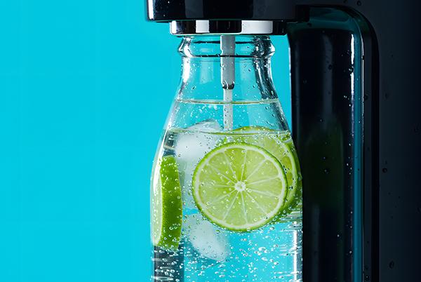 a glass bottle filled with water and lime slices on top