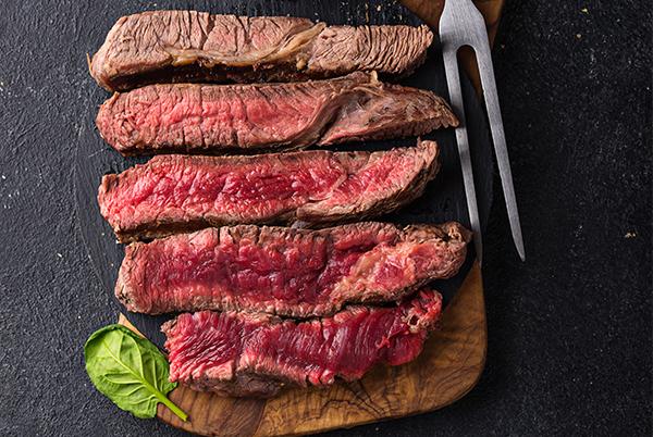 steak with a knife and fork on a cutting board