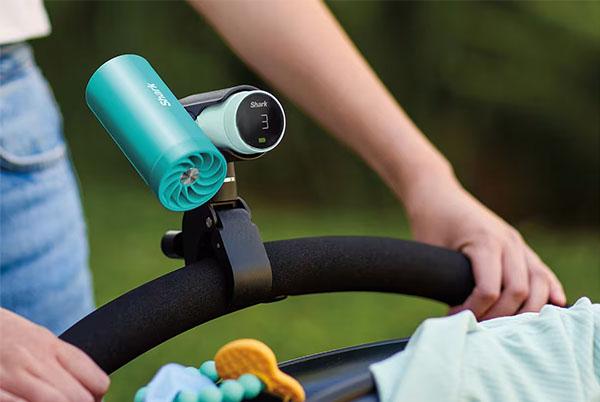 a person holding a camera in front of a baby stroller