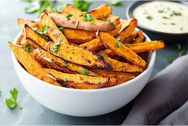 sweet potato fries in a white bowl with a dipping sauce