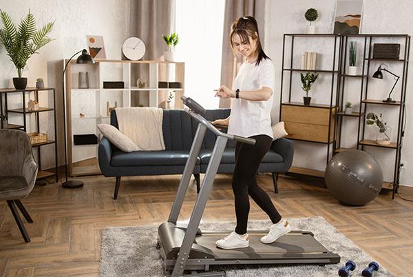 a woman is on a treadmill in a living room