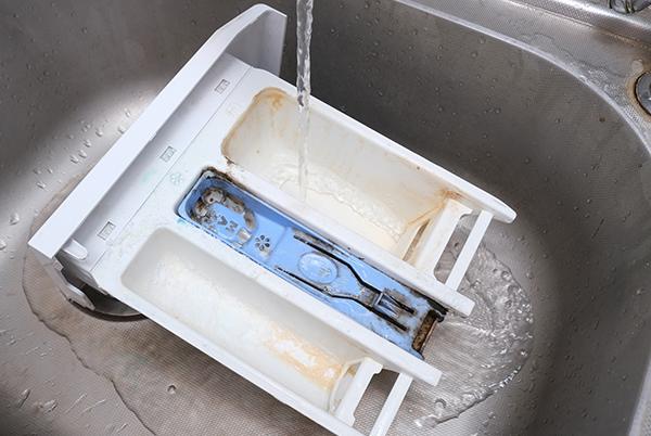 a sink with a drain that is open and a dishwasher