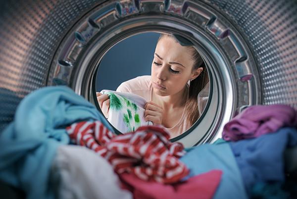 a woman looking at herself in a reflection in a washing machine