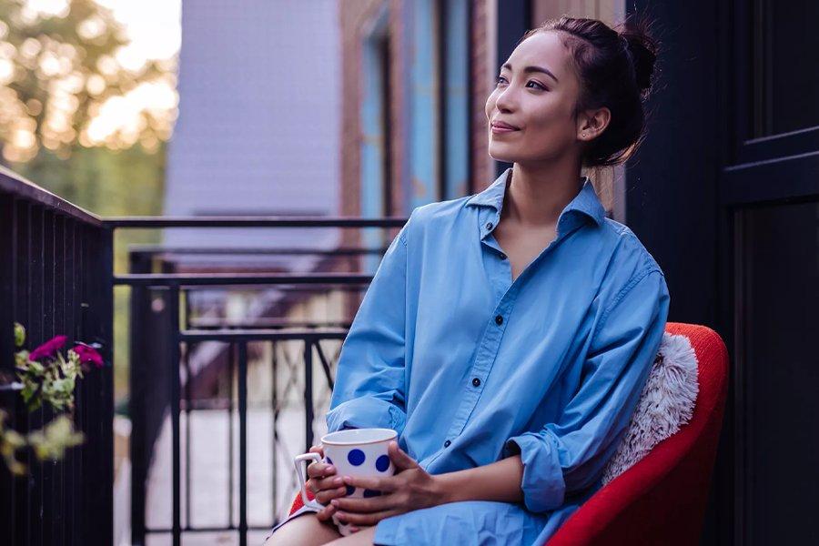 A woman sitting outside holding a mug