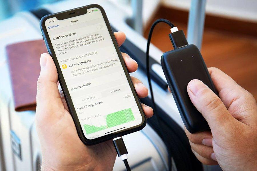 A person holding a phone and a power bank