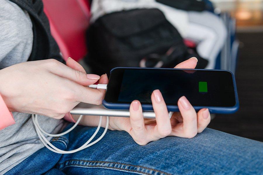 A pair of hands putting a cable into a mobile phone and a power bank