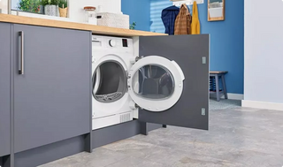 An tumble dryer inside a cupboard in a kitchen