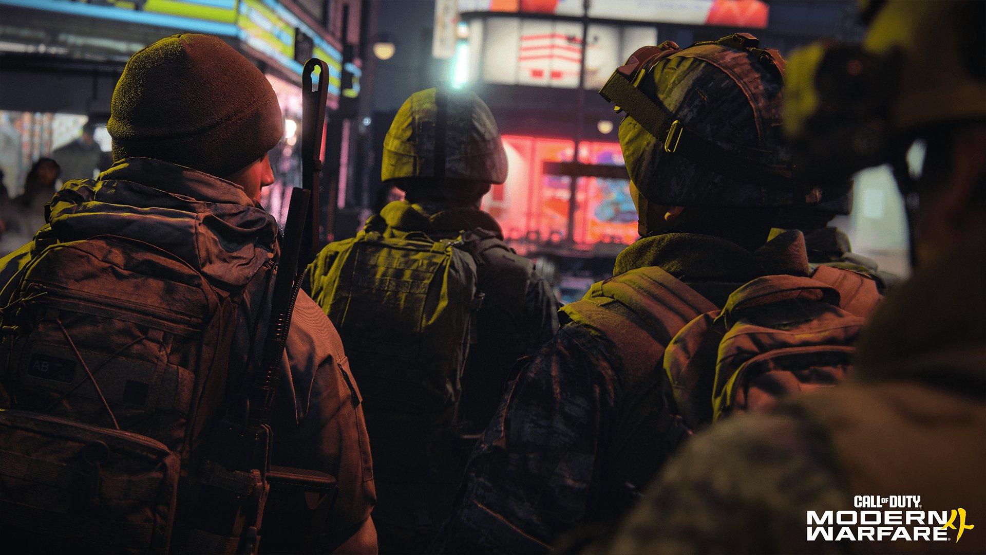 The back of four soldiers as they walk through a city