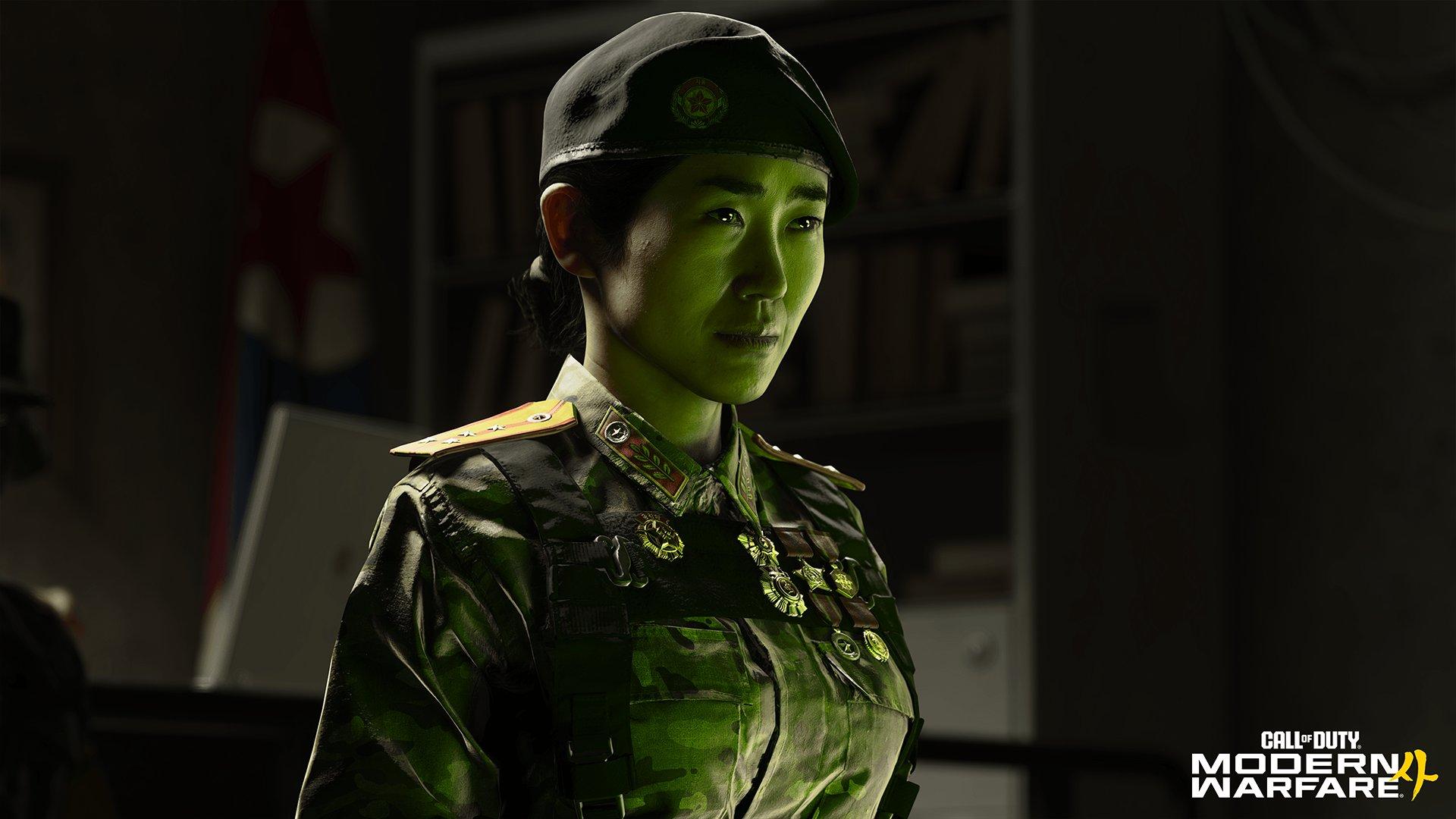 A soldier stands looking into the distance with a green light shining on them