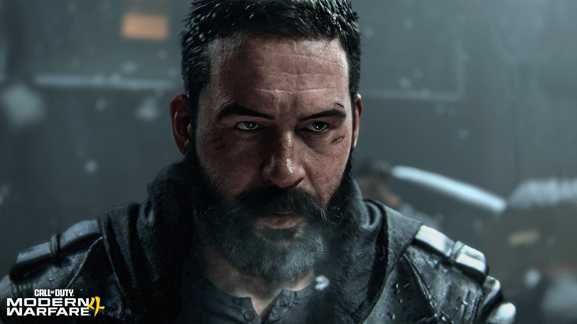A man with a beard and cuts on his face stares intensely 