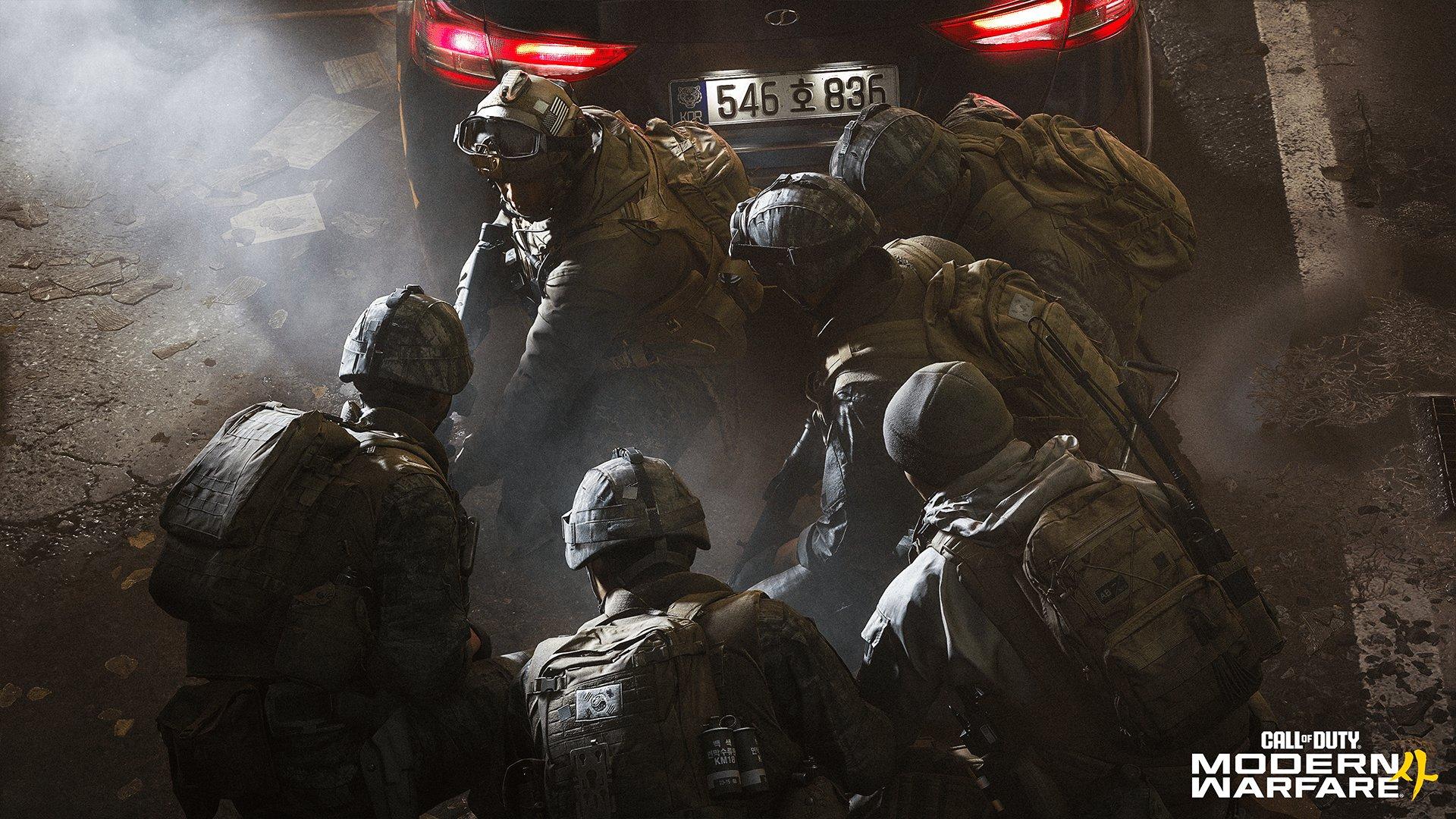A group of six soldiers crouched over next to a car