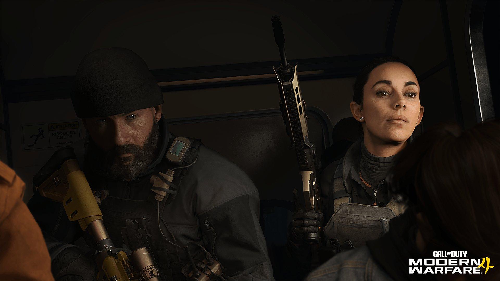 Two soldiers sitting in a vehicle holding guns