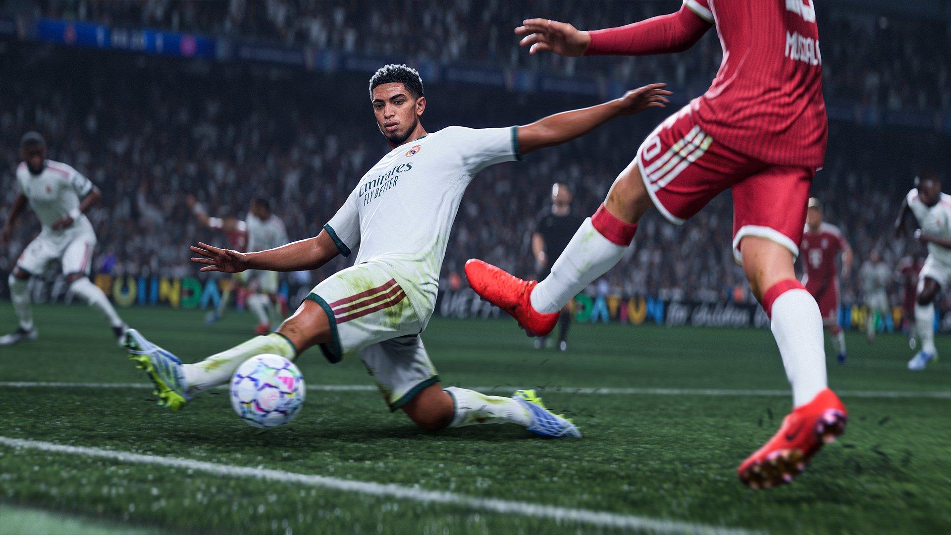 A football player sliding across the pitch with a football in front of him
