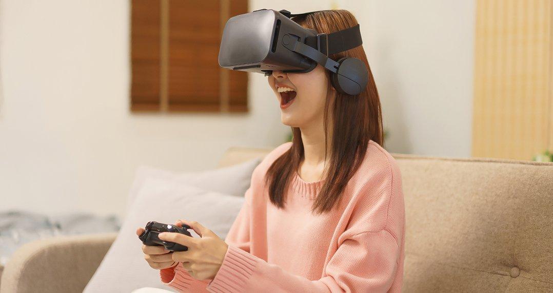 a woman sitting on a couch playing a video game with a virtual reality headset