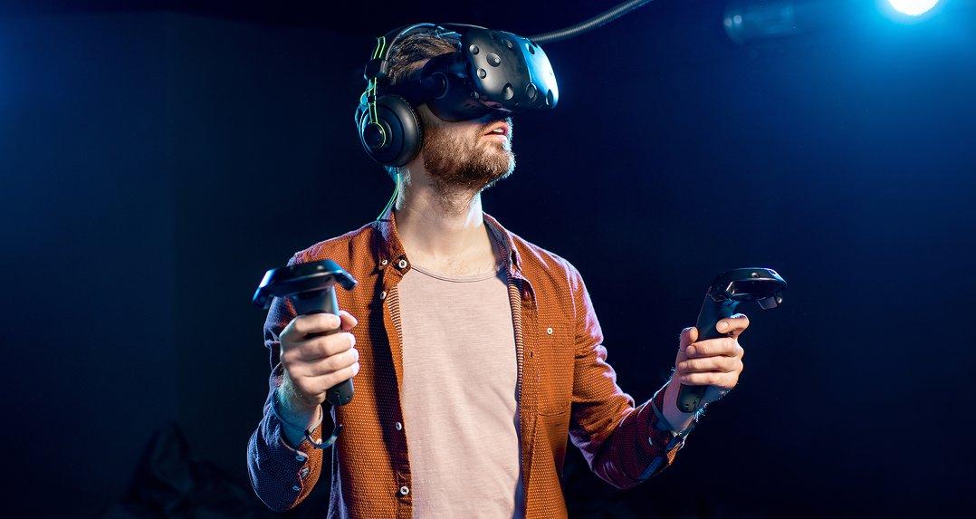 a man wearing a headset and holding two controllers