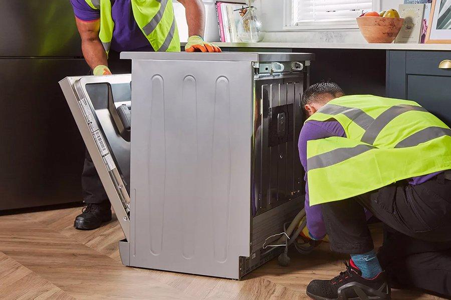 Two Currys colleagues installing a washing machine