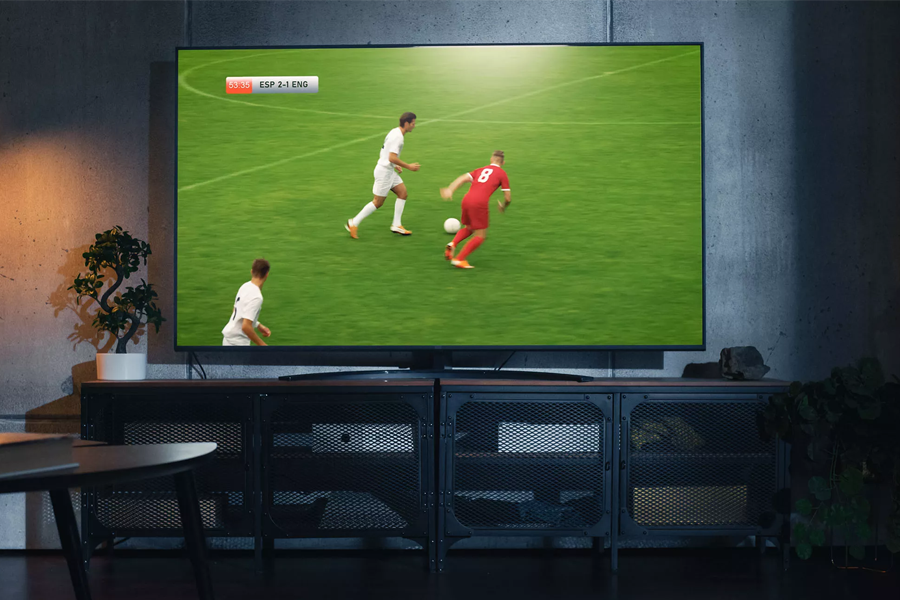 A large TV on a shelf with a football game on the screen