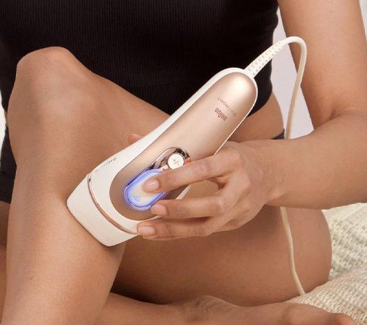 woman removing hair on her leg using a Braun Silk-expert IPL device
