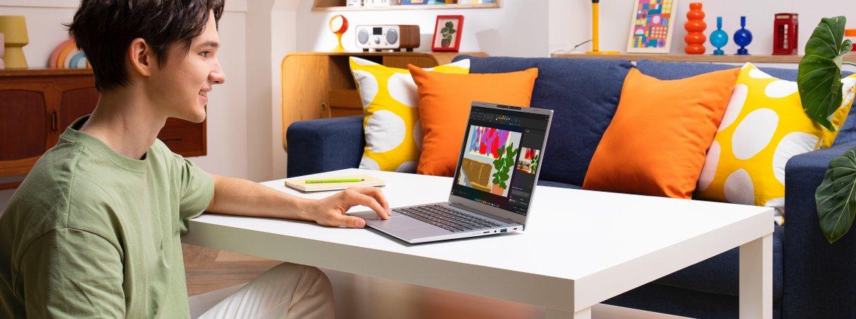 A person sitting on the floor using a laptop that's on a coffee table