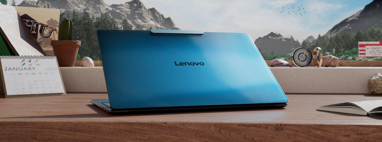A Lenovo laptop on a desk in front of a window